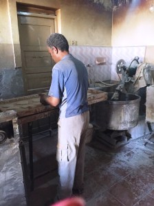 Mahmouds assistant putting it in the oven