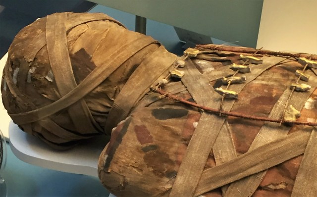 The golden figures are charms called amulets, often hidden between the strips to protect from evil